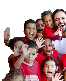 Um grupo de crianças sorridentes a acenar, vestindo t-shirts vermelhas da Colgate, ao lado de um homem sorridente de camisa branca.